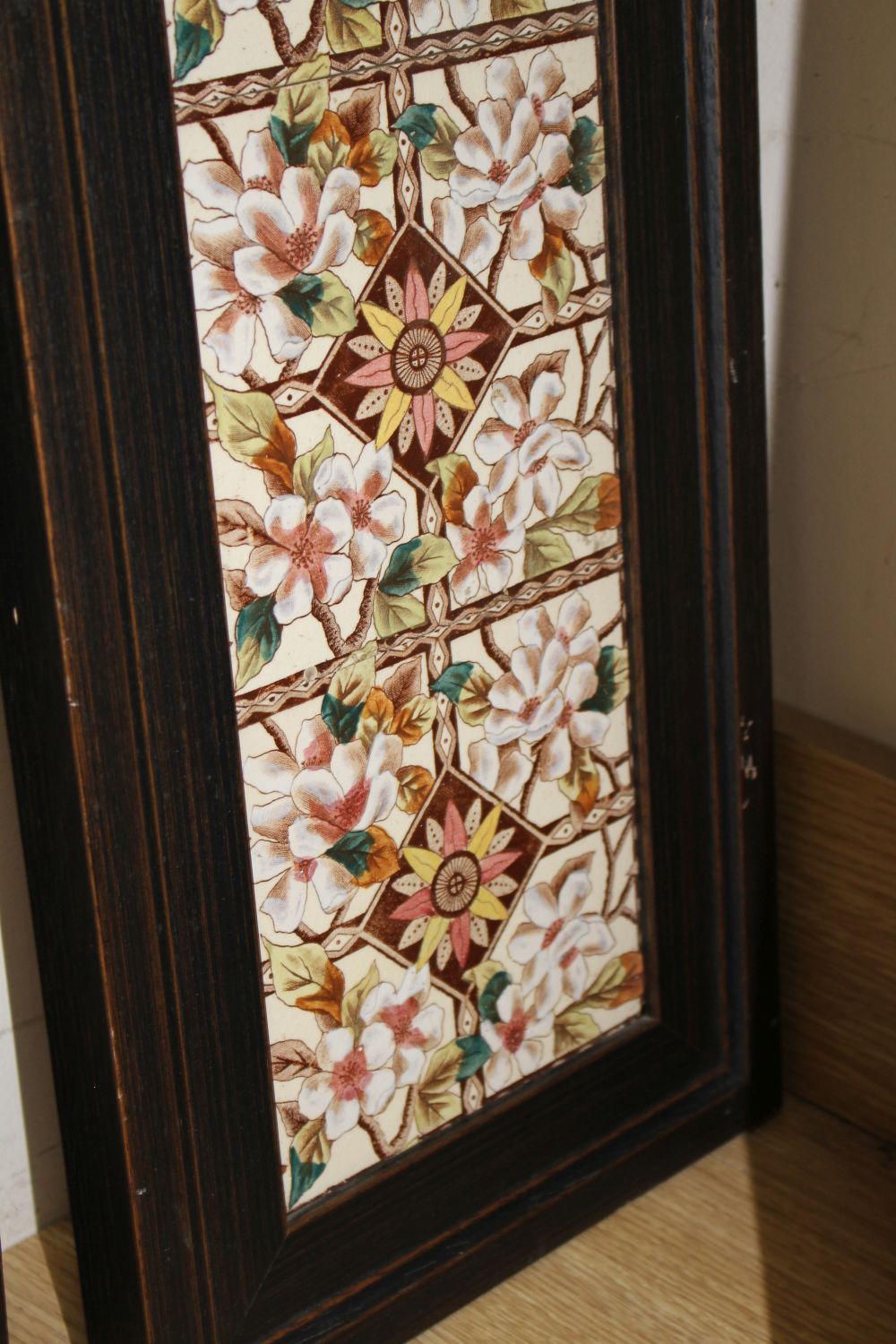 A pair of Victorian apple blossom tile panels and a set of six Art Nouveau foliate design tiles, all framed